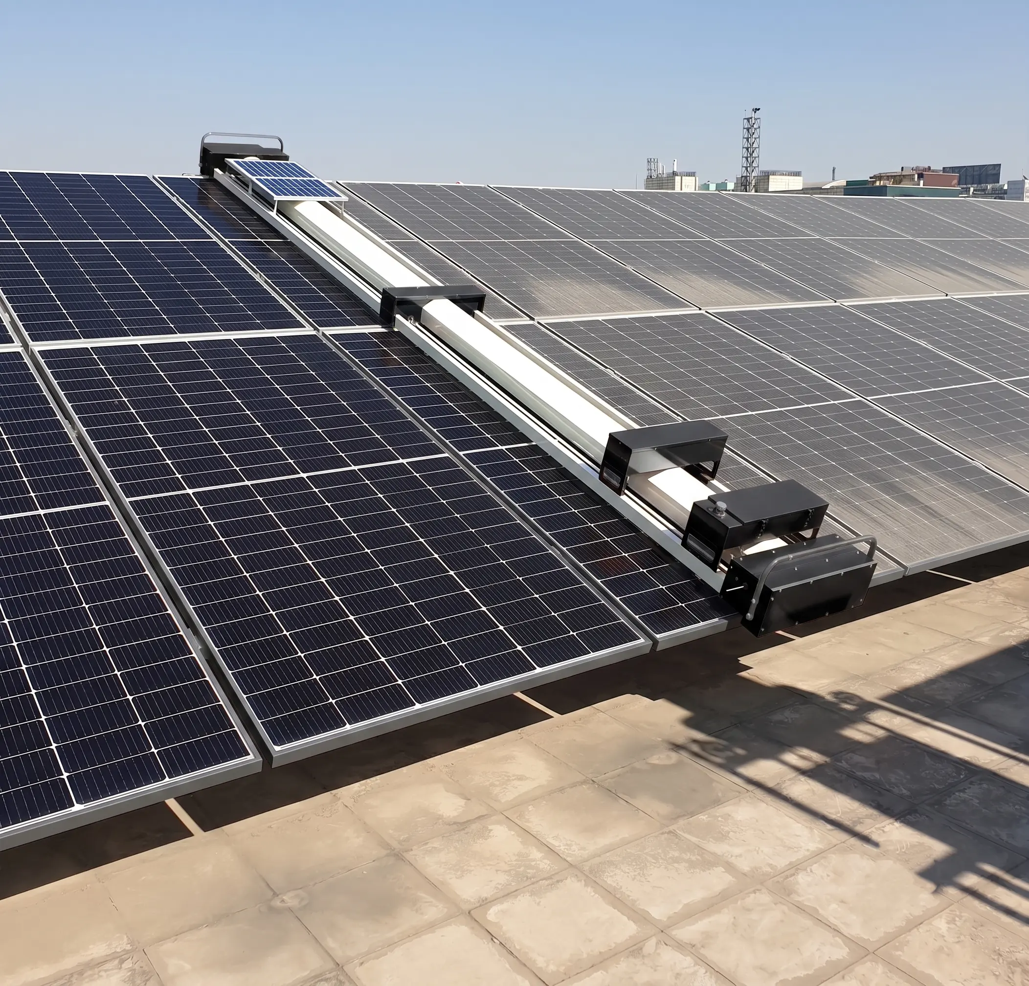 OpenDroids cleaning robot moving along a long row of ground mount utility solar panels with full array visible in the background