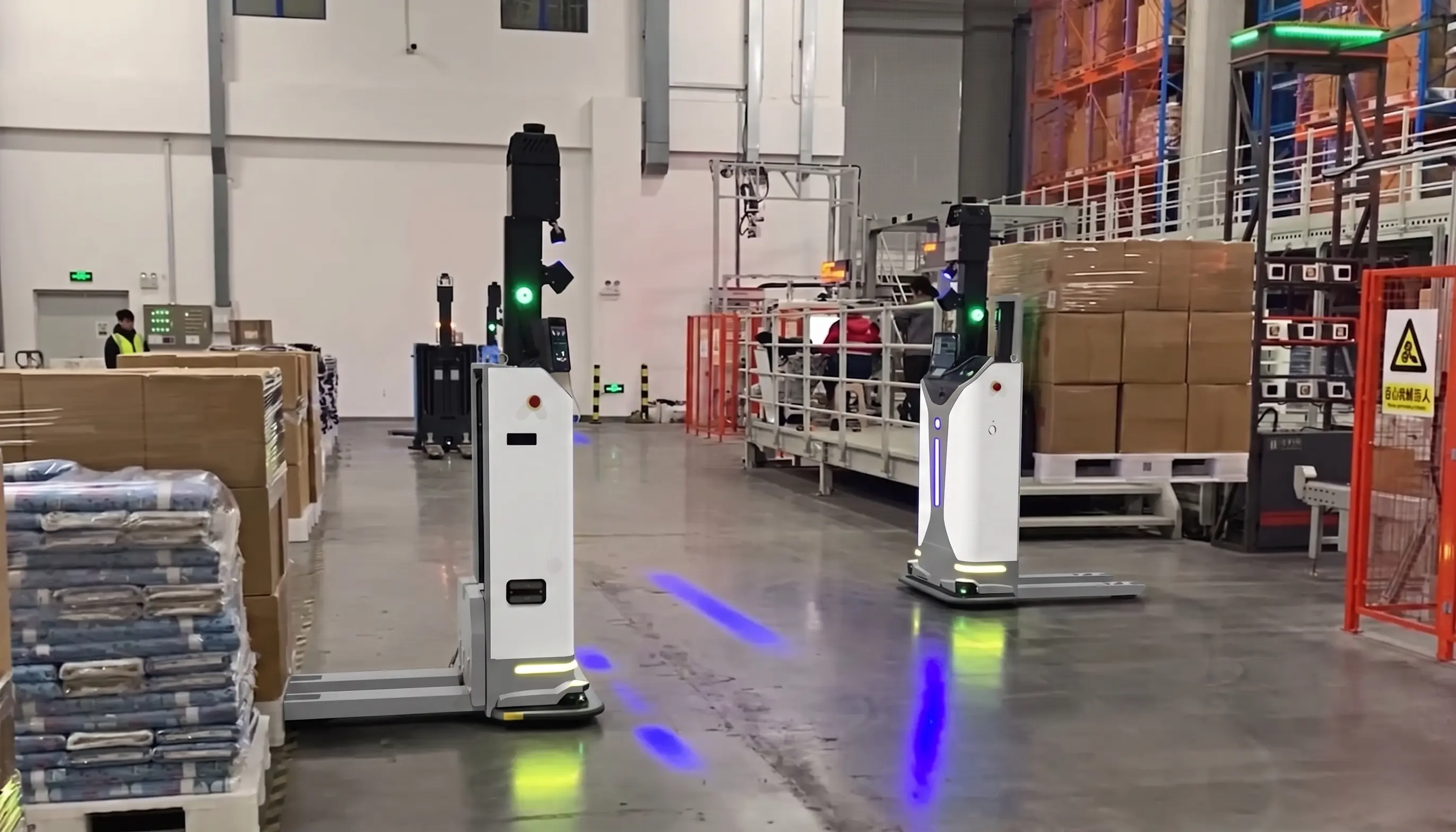 OpenDroids robot routing totes toward labeled sortation chutes in a warehouse